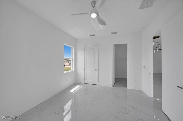 420-422 Grant Blvd, Lehigh Acres, FL 33974 - unfurnished bedroom featuring marble finish floors, a ceiling fan, and a walk in closet