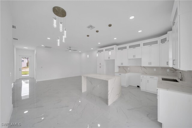 420-422 Grant Blvd, Lehigh Acres, FL 33974 - kitchen with light marble finish floors, recessed lighting, light stone countertops, glass insert cabinets, and white cabinets