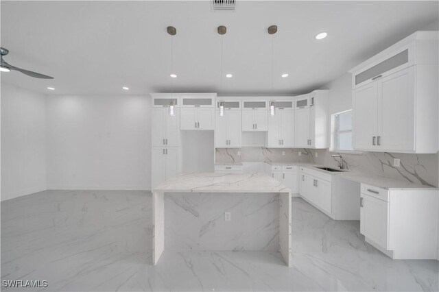420-422 Grant Blvd, Lehigh Acres, FL 33974 - kitchen with light marble finish floors, recessed lighting, a kitchen island, glass insert cabinets, and decorative light fixtures