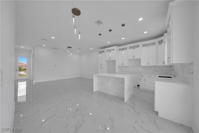 420-422 Grant Blvd, Lehigh Acres, FL 33974 - kitchen featuring light marble finish flooring, recessed lighting, glass insert cabinets, white cabinetry, and hanging light fixtures
