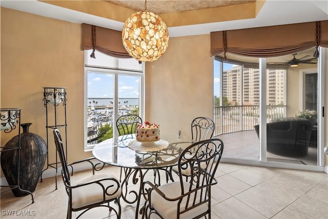 6021 Silver King Blvd Unit 302, Cape Coral, FL 33914 - dining area with light tile patterned floors, ceiling fan, a tray ceiling, and a city view