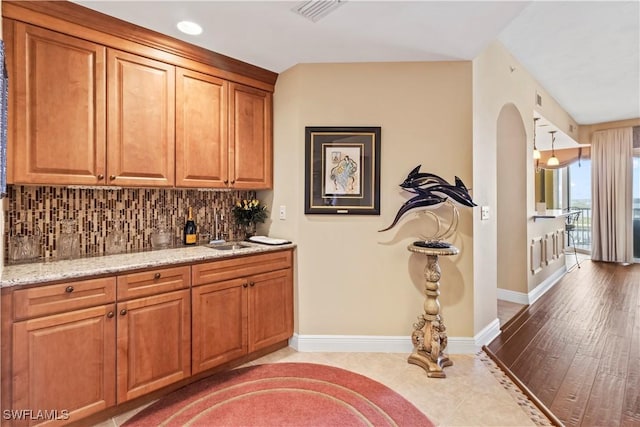 6021 Silver King Blvd Unit 302, Cape Coral, FL 33914 - bar with backsplash, arched walkways, and light wood-style floors