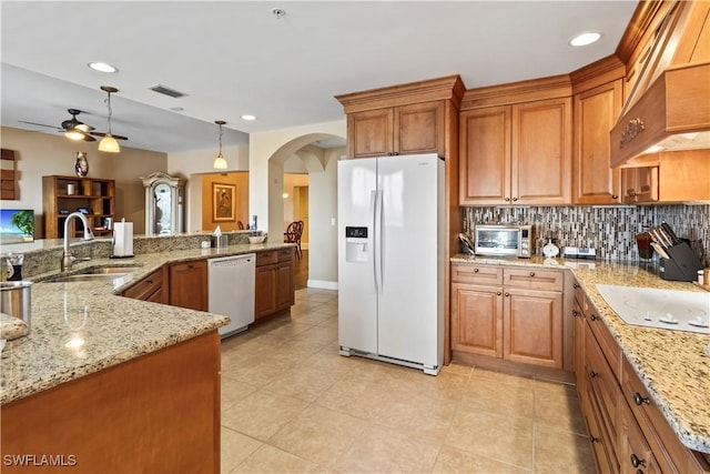 6021 Silver King Blvd Unit 302, Cape Coral, FL 33914 - kitchen with white appliances, a ceiling fan, brown cabinets, light stone countertops, and arched walkways