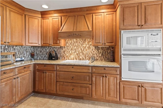 6021 Silver King Blvd Unit 302, Cape Coral, FL 33914 - kitchen with white appliances, custom exhaust hood, backsplash, light stone countertops, and light tile patterned floors