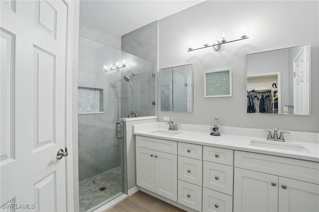 2232 Carnaby Ct, Lehigh Acres, FL 33973 - bathroom featuring a shower stall, double vanity, and a walk in closet