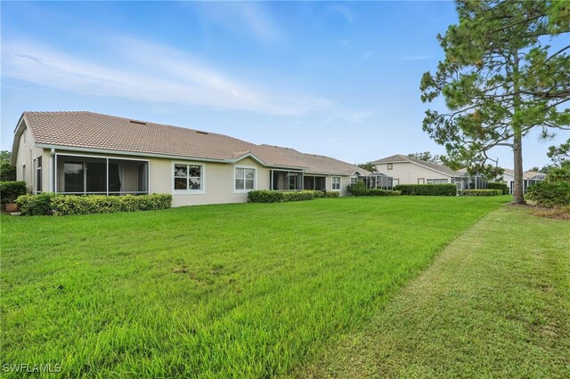 2232 Carnaby Ct, Lehigh Acres, FL 33973 - rear view of property with a tile roof, a lawn, and stucco siding