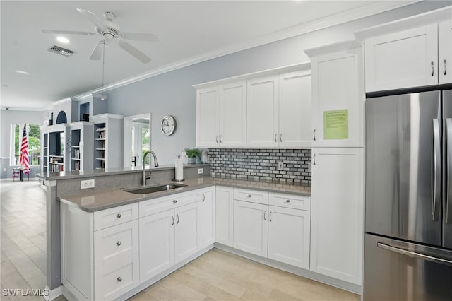 2232 Carnaby Ct, Lehigh Acres, FL 33973 - kitchen featuring freestanding refrigerator, ceiling fan, a peninsula, decorative backsplash, and white cabinets