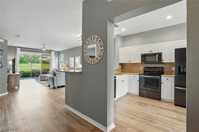2232 Carnaby Ct, Lehigh Acres, FL 33973 - kitchen with stainless steel microwave, range with electric cooktop, black fridge with ice dispenser, backsplash, and open floor plan