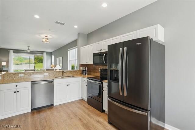 2232 Carnaby Ct, Lehigh Acres, FL 33973 - kitchen featuring black appliances, light stone countertops, white cabinetry, and recessed lighting