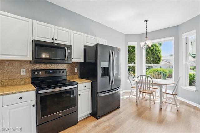 2232 Carnaby Ct, Lehigh Acres, FL 33973 - kitchen with appliances with stainless steel finishes, backsplash, white cabinets, light wood-type flooring, and a chandelier