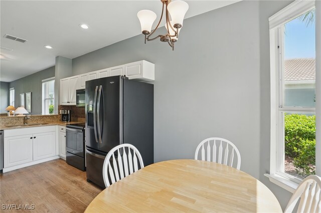 2232 Carnaby Ct, Lehigh Acres, FL 33973 - dining space with light wood-style floors, recessed lighting, and a chandelier