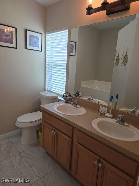8340 Gassner Way, Lehigh Acres, FL 33972 - bathroom with double vanity, toilet, and a bath