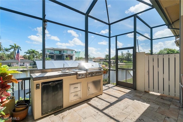 431 Palm Ct, Naples, FL 34108 - view of patio featuring an outdoor kitchen, glass enclosure, a water view, and a residential view