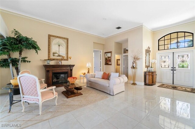 431 Palm Ct, Naples, FL 34108 - living room featuring crown molding, a glass covered fireplace, light tile patterned floors, and a high ceiling