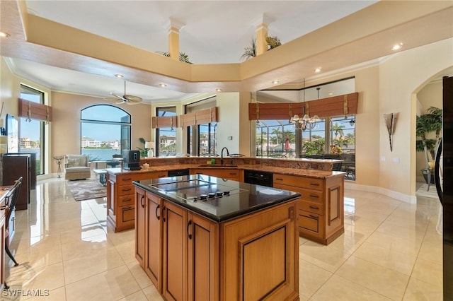 431 Palm Ct, Naples, FL 34108 - kitchen with a center island, brown cabinetry, black electric cooktop, open floor plan, and arched walkways