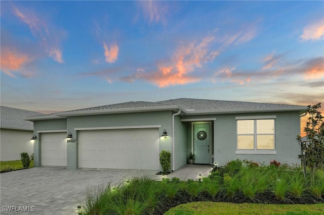 16420 Settlers Way, Punta Gorda, FL 33982 - view of front of house featuring a garage, stucco siding, and decorative driveway