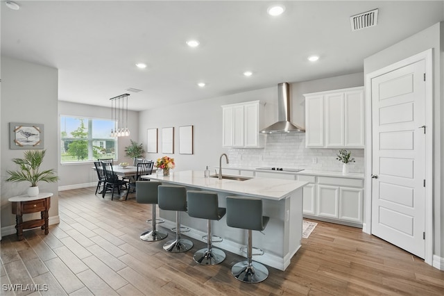 16420 Settlers Way, Punta Gorda, FL 33982 - kitchen with wall chimney range hood, white cabinets, backsplash, black electric stovetop, and recessed lighting
