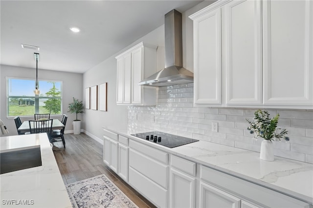 16420 Settlers Way, Punta Gorda, FL 33982 - kitchen with wall chimney range hood, black electric stovetop, white cabinetry, backsplash, and recessed lighting