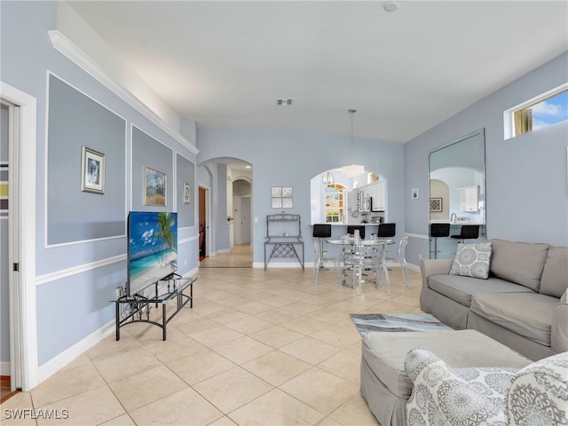 8627 Ibis Cove Cir, Naples, FL 34119 - living area featuring arched walkways, light tile patterned flooring, and a chandelier