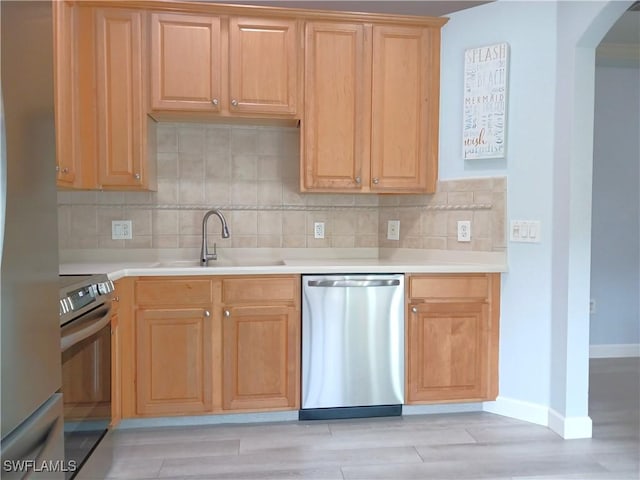 7725 Woodbrook Cir Unit 3504, Naples, FL 34104 - kitchen featuring appliances with stainless steel finishes, arched walkways, tasteful backsplash, and light countertops