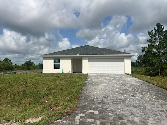 658 Ivanhoe Ave S, Lehigh Acres, FL 33974 - ranch-style home with stucco siding, decorative driveway, a front lawn, an attached garage, and roof with shingles