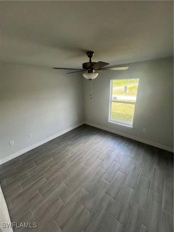 658 Ivanhoe Ave S, Lehigh Acres, FL 33974 - empty room featuring wood tiled floors, baseboards, and ceiling fan