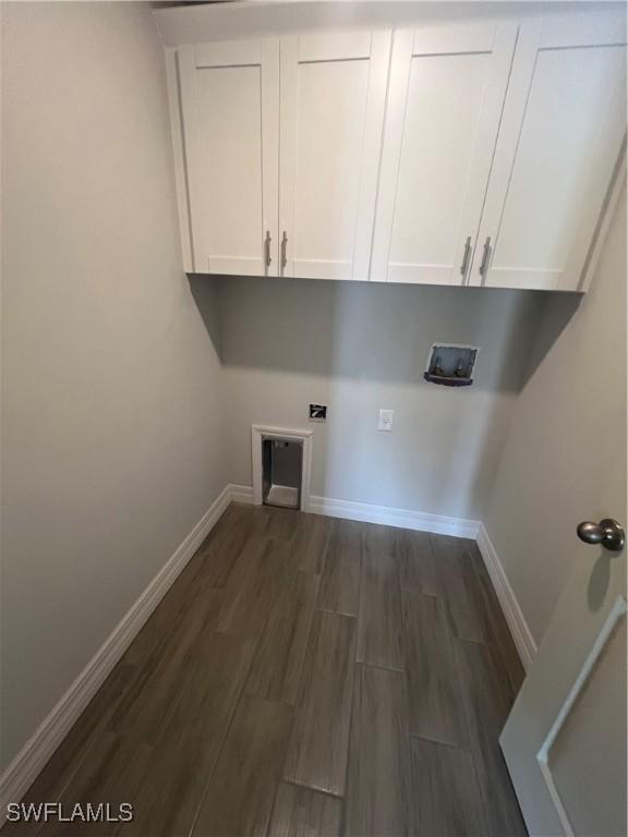 658 Ivanhoe Ave S, Lehigh Acres, FL 33974 - laundry room with dark wood-type flooring, cabinet space, baseboards, and hookup for an electric dryer