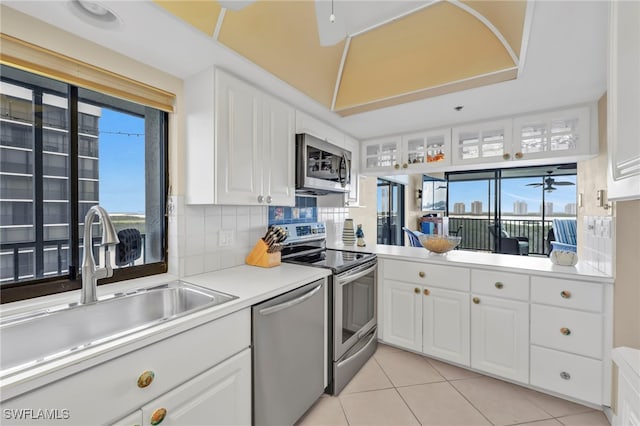 26235 Hickory Blvd Unit 9A, Bonita Springs, FL 34134 - kitchen with stainless steel appliances, white cabinetry, light tile patterned floors, backsplash, and light countertops