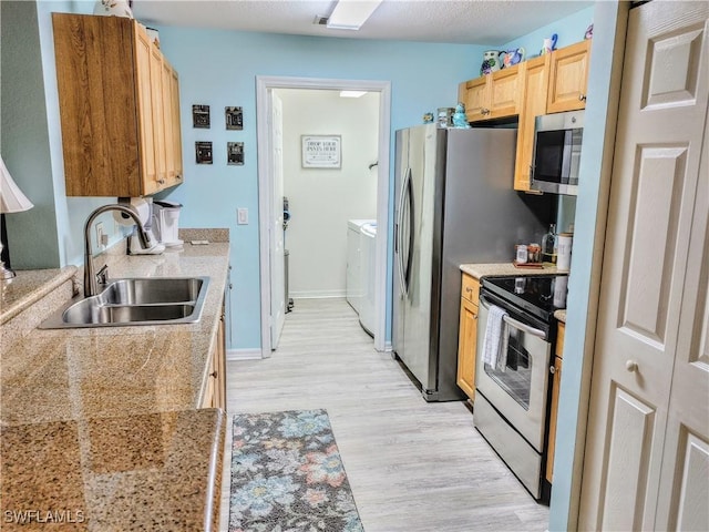 1776 Concordia Lake Cir Unit 2902, Cape Coral, FL 33909 - kitchen with a sink, appliances with stainless steel finishes, separate washer and dryer, light wood-type flooring, and light brown cabinets