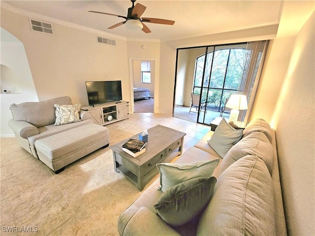 12975 Positano Cir Unit 104, Naples, FL 34105 - living area with ceiling fan, light tile patterned floors, ornamental molding, and arched walkways