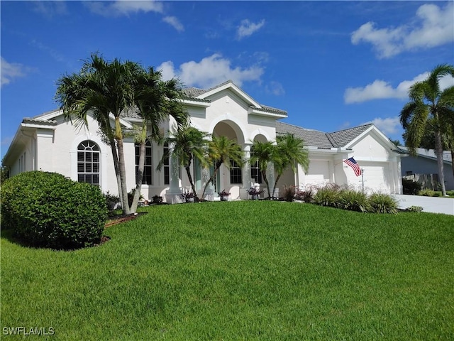 17091 Laurelin Ct, North Fort Myers, FL 33917 - mediterranean / spanish-style home with a garage, a front lawn, stucco siding, concrete driveway, and a tile roof