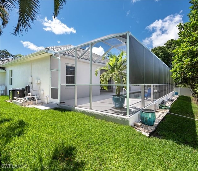 17091 Laurelin Ct, North Fort Myers, FL 33917 - back of house featuring a patio, stucco siding, a yard, and a lanai