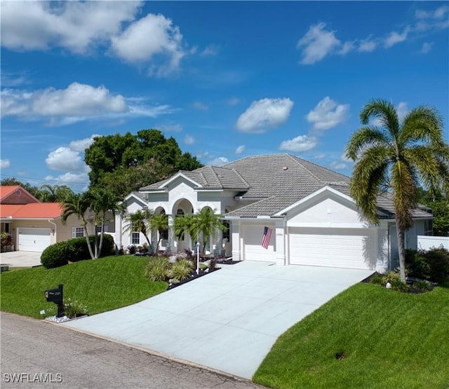 17091 Laurelin Ct, North Fort Myers, FL 33917 - view of front of home featuring a garage, a front yard, concrete driveway, stucco siding, and a tile roof
