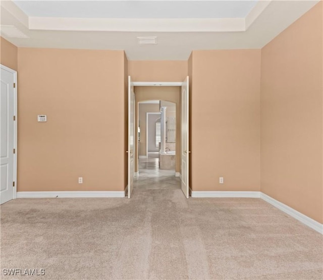17091 Laurelin Ct, North Fort Myers, FL 33917 - unfurnished room with light carpet, a tray ceiling, and arched walkways
