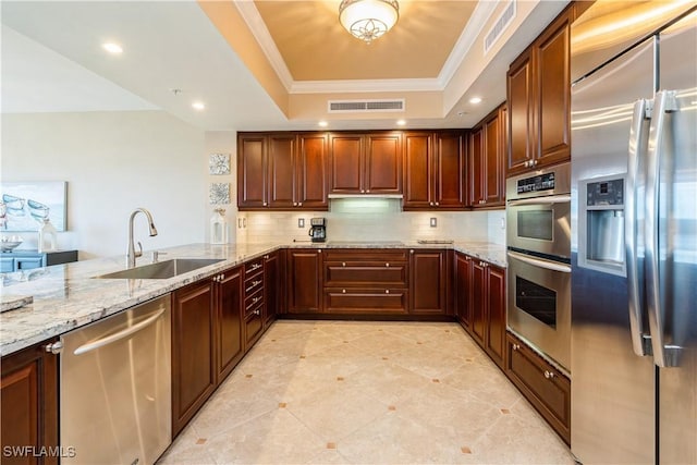 1050 Borghese Ln Unit 605, Naples, FL 34114 - kitchen featuring appliances with stainless steel finishes, a tray ceiling, ornamental molding, decorative backsplash, and light stone countertops