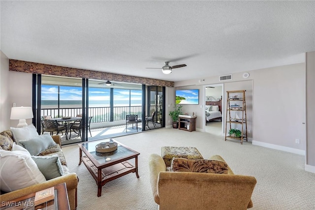 100 N Collier Blvd Unit 303, Marco Island, FL 34145 - living area with carpet flooring, ceiling fan, baseboards, healthy amount of natural light, and a textured ceiling