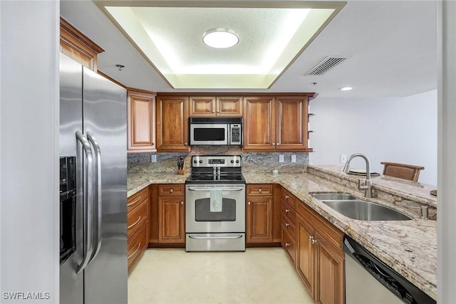 100 N Collier Blvd Unit 303, Marco Island, FL 34145 - kitchen with appliances with stainless steel finishes, a sink, brown cabinetry, and backsplash