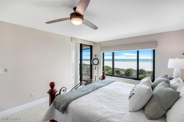 100 N Collier Blvd Unit 303, Marco Island, FL 34145 - carpeted bedroom with access to exterior, a ceiling fan, baseboards, a water view, and a textured ceiling