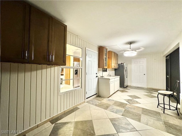 1110 Rushmore Ave N, Lehigh Acres, FL 33936 - kitchen with freestanding refrigerator, a ceiling fan, light countertops, glass insert cabinets, and dark brown cabinets