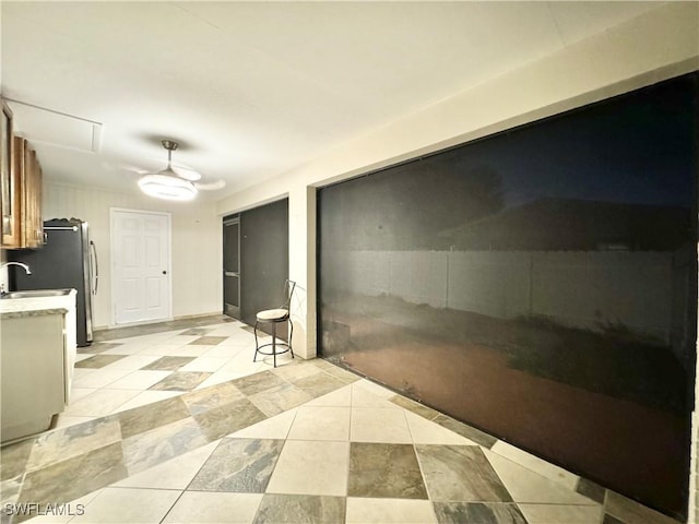 1110 Rushmore Ave N, Lehigh Acres, FL 33936 - kitchen with light tile patterned floors, light countertops, freestanding refrigerator, and a ceiling fan