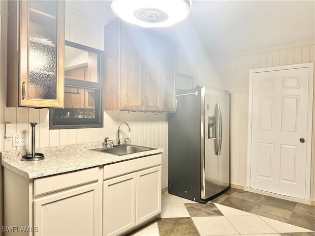 1110 Rushmore Ave N, Lehigh Acres, FL 33936 - kitchen featuring stainless steel fridge, glass insert cabinets, light tile patterned floors, wood walls, and light stone countertops