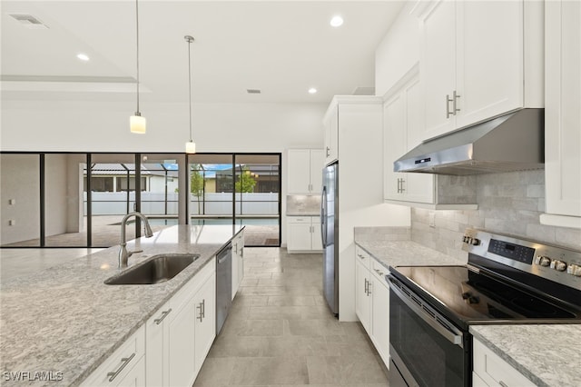 3318 NW 1st Ter, Cape Coral, FL 33993 - kitchen with stainless steel appliances, under cabinet range hood, backsplash, white cabinetry, and recessed lighting