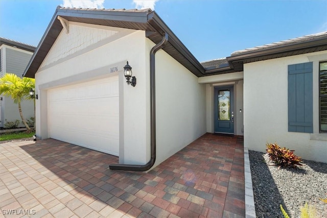 16176 Rosemallow Ln, Alva, FL 33920 - entrance to property featuring stucco siding, a garage, and decorative driveway