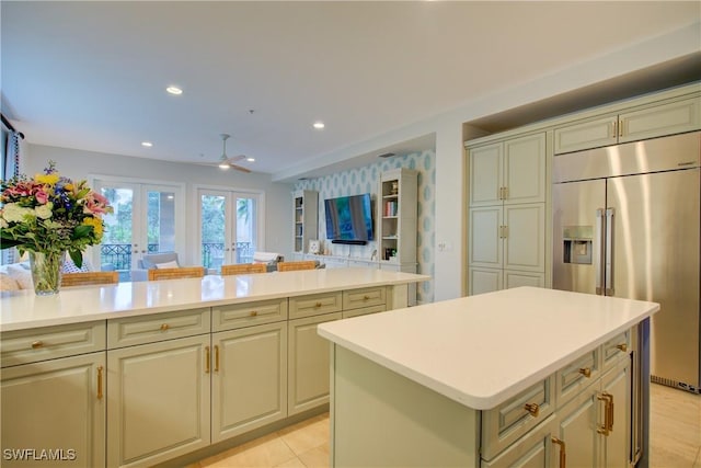 2855 Tiburon Blvd E Unit 102, Naples, FL 34109 - kitchen with built in fridge, light countertops, french doors, a center island, and a ceiling fan