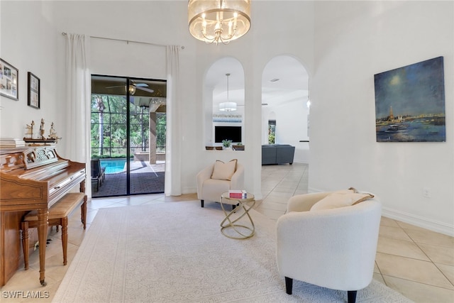 7327 Acorn Way, Naples, FL 34119 - tiled living area featuring arched walkways, a towering ceiling, plenty of natural light, a chandelier, and ceiling fan