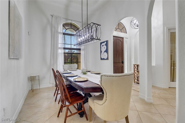 7327 Acorn Way, Naples, FL 34119 - dining space with arched walkways, light tile patterned floors, a high ceiling, baseboards, and a chandelier