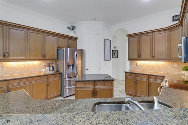 7327 Acorn Way, Naples, FL 34119 - kitchen with appliances with stainless steel finishes, a sink, arched walkways, dark stone countertops, and crown molding