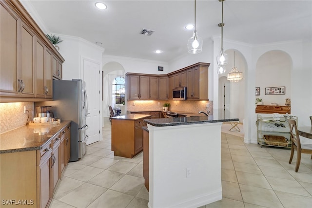 7327 Acorn Way, Naples, FL 34119 - kitchen with arched walkways, stainless steel appliances, light tile patterned floors, backsplash, and crown molding