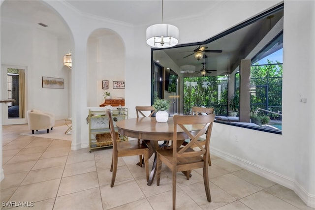 7327 Acorn Way, Naples, FL 34119 - dining room with arched walkways, light tile patterned floors, a ceiling fan, ornamental molding, and baseboards