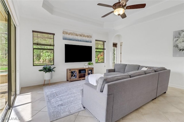 7327 Acorn Way, Naples, FL 34119 - living area with light tile patterned floors, a tray ceiling, arched walkways, ceiling fan, and crown molding